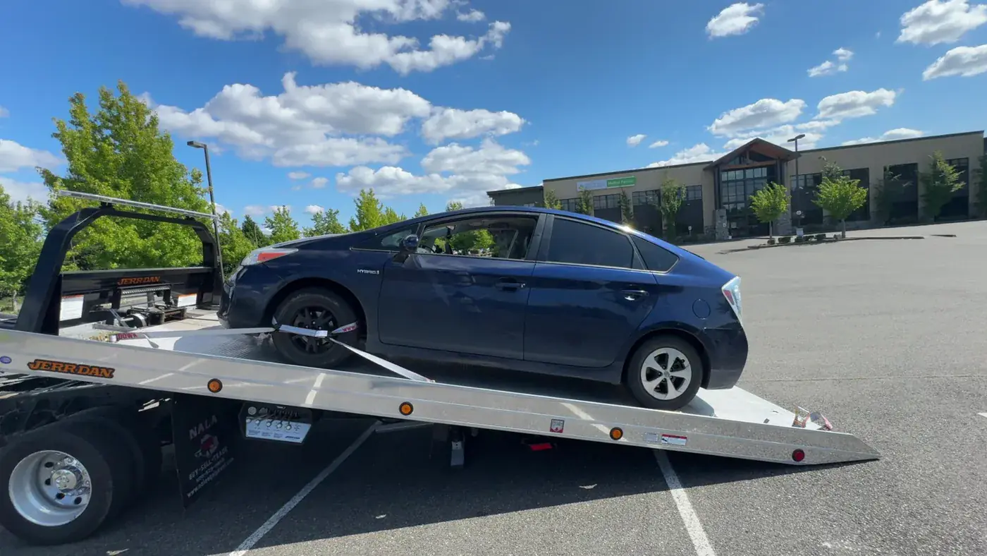 Blue Prius loaded on the Pathfinder Towing rollback flatbed