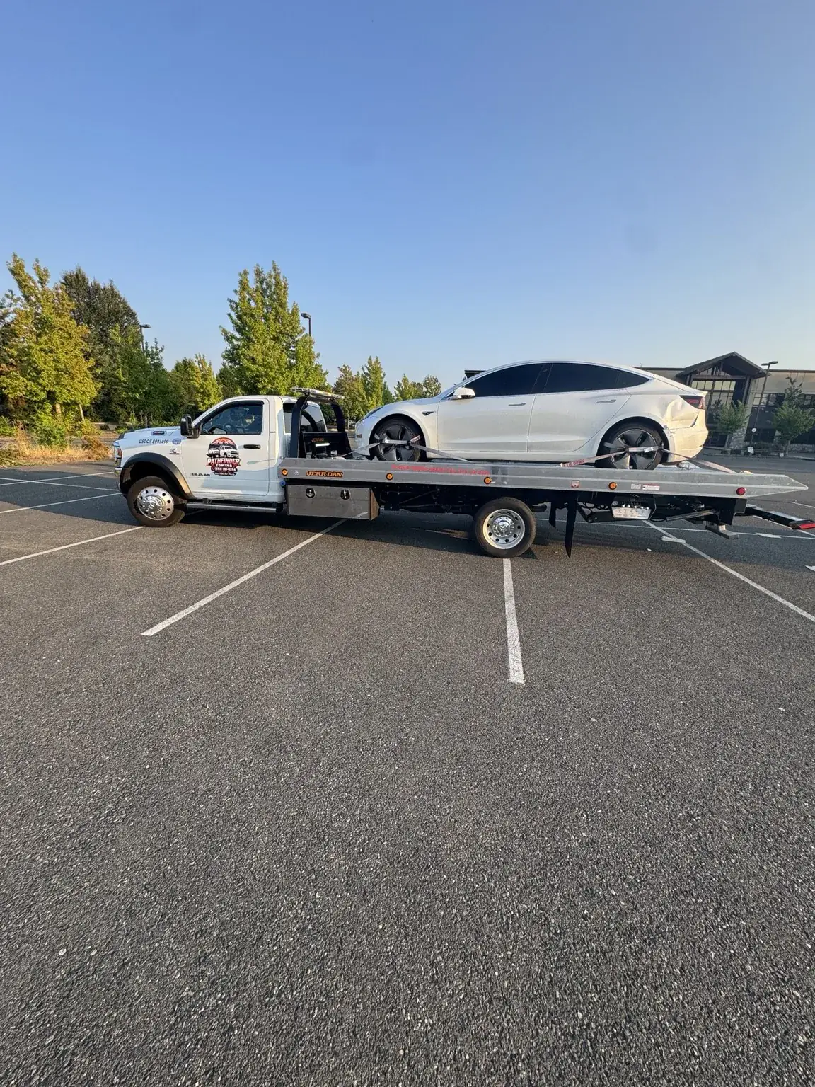 Pathfinder Towing rollback carrying a Tesla