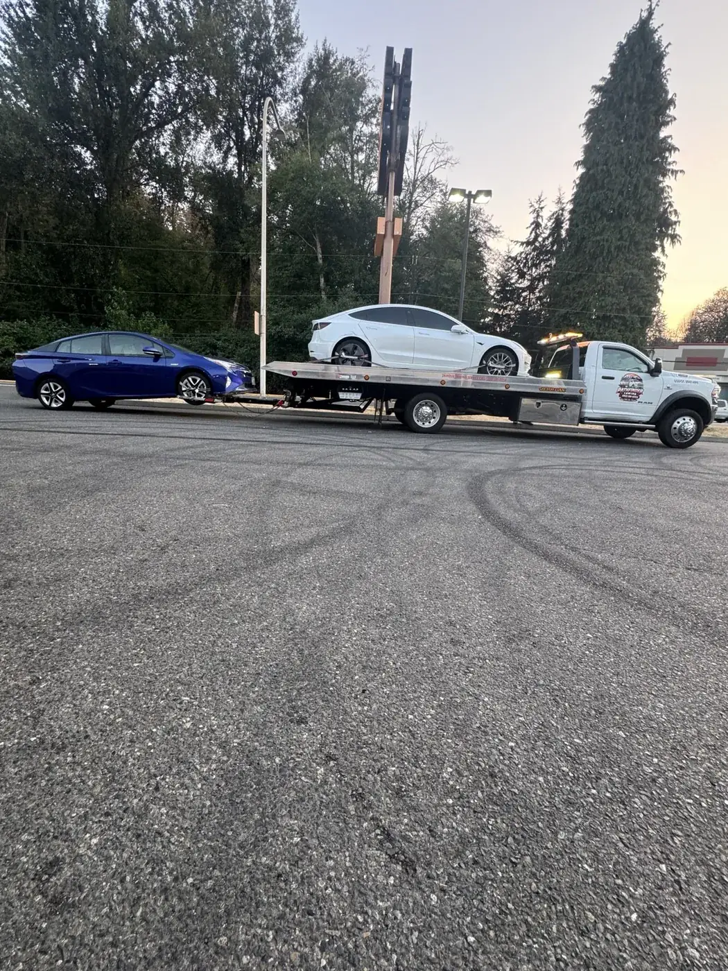 Pathfinder Towing rollback transporting two vehicles during a daytime service