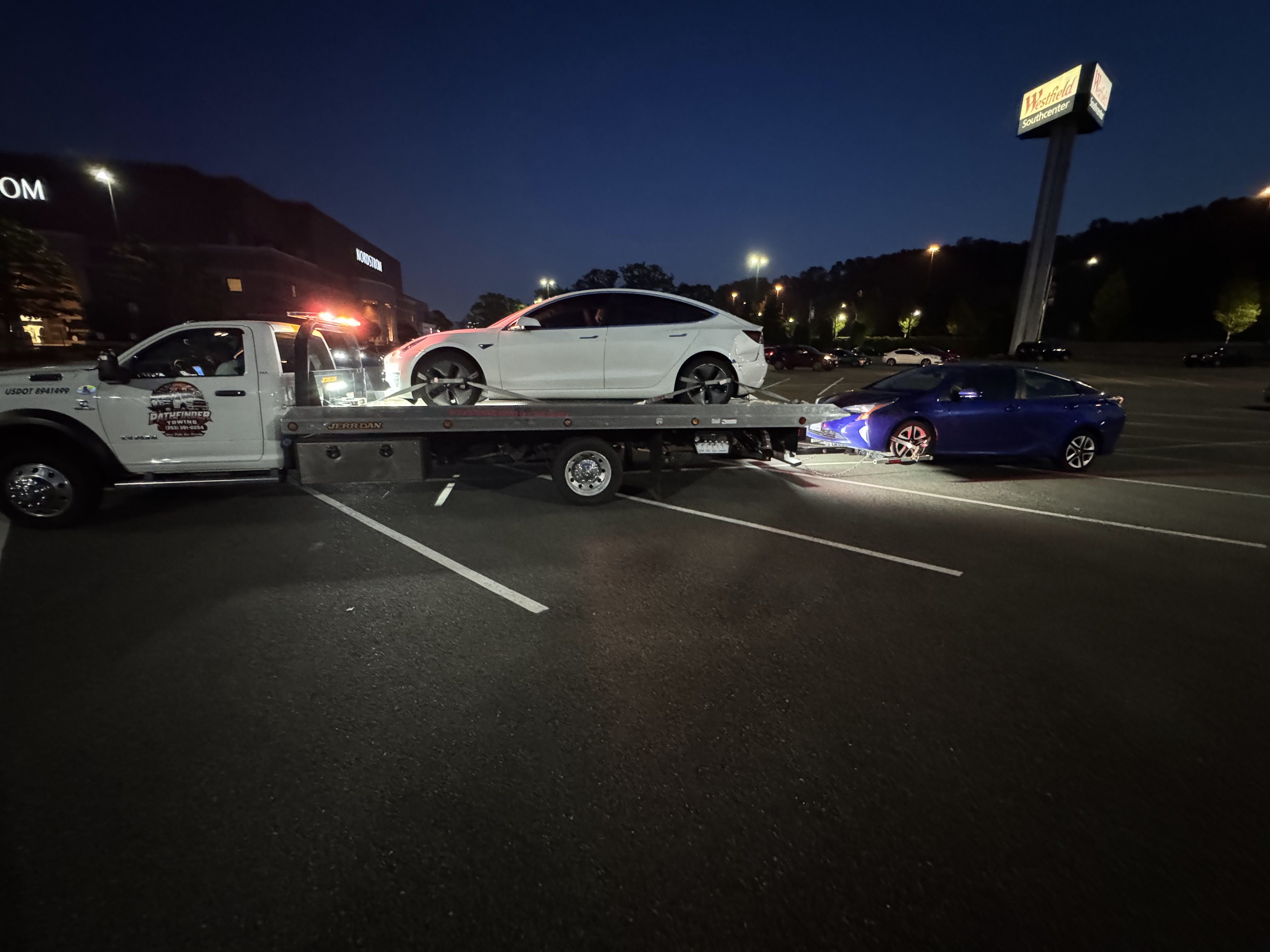 Pathfinder Towing transporting two vehicles near Southcenter at night